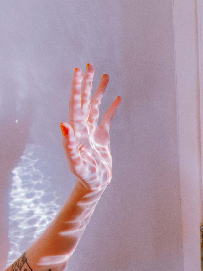 Unrecognizable woman with wavy sunlight on hand